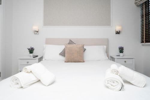a bedroom with a white bed with towels on it at Howburn Residence Serviced Apartments in Aberdeen