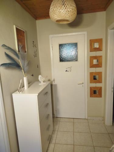 a room with a white dresser and a white door at The happy scarecrows in Amalias