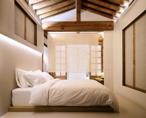 a bedroom with a white bed and a window at Hyowudang in Gyeongju