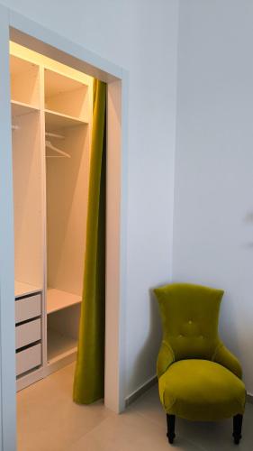 a green chair sitting in front of a closet at La Foresteria Termoli in Termoli