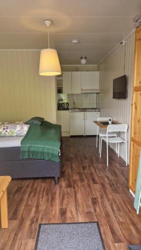 una camera con letto e tavolo e una cucina di Kvamsdal Pensjonat 2 a Eidfjord