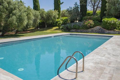 a swimming pool in a yard with trees and bushes at Agriturismo Il Bagolaro in Nerola