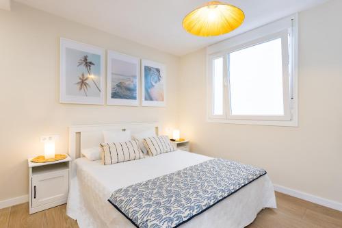 ein weißes Schlafzimmer mit einem Bett und einem Fenster in der Unterkunft Maresía Home in Bajamar