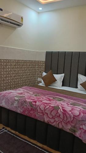 a bedroom with a bed with pink sheets and pillows at Govind Anand Dham in Vrindāvan