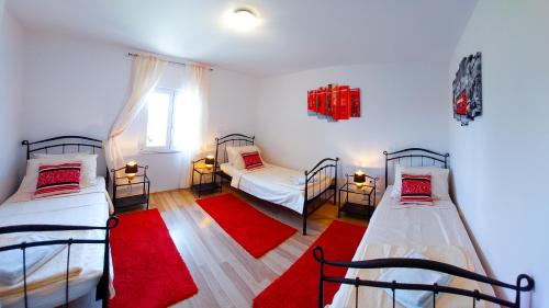 a room with two beds and a red rug at Mendys Sea View - Pomalo & Fjaka Retreat in Kaštela