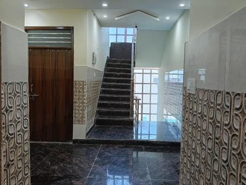 a hallway with a wooden door and a staircase at Govind Anand Dham in Vrindāvan