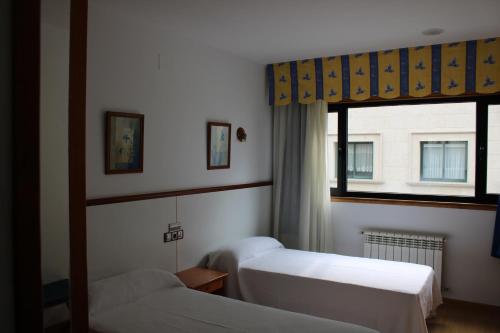 a bedroom with two beds and a window at Hotel Villa de Ares in Ares