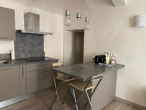 une cuisine avec une table et des chaises dans une pièce dans l'établissement T2 Sartène centre ville, à Portigliolo