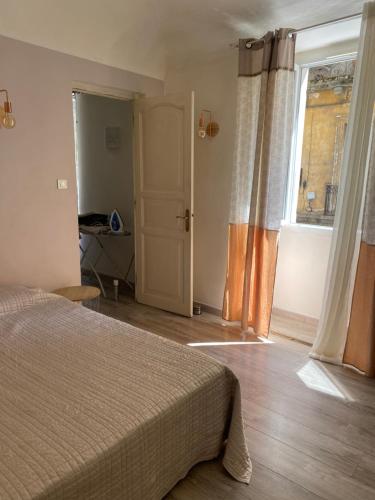 a bedroom with a bed and a large window at T2 Sartène centre ville in Portigliolo