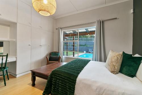una camera da letto con un letto, una scrivania e una finestra di Hot Tub Haven - Back up electricity Plett a Plettenberg Bay