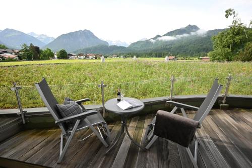 a patio with a table and two chairs and a field at Best Western Plus Hotel Alpenhof in Oberstdorf