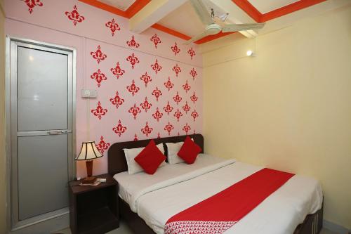 DānāpurにあるHotel O Magadh Vilasのベッドルーム1室(赤い枕のベッド1台付)