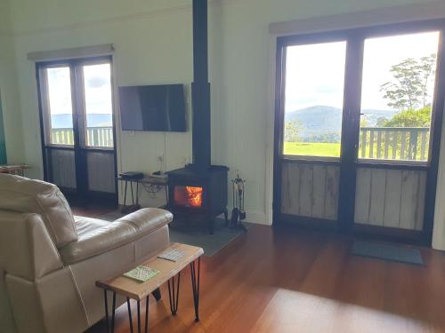 a living room with a couch and a fireplace at Couples Accessible Cabin, Zarina Country Cabins, 6 in Witta