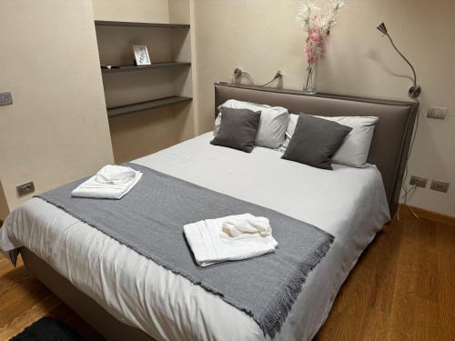 a bedroom with a large bed with towels on it at Bon Bon Cavour in Asti
