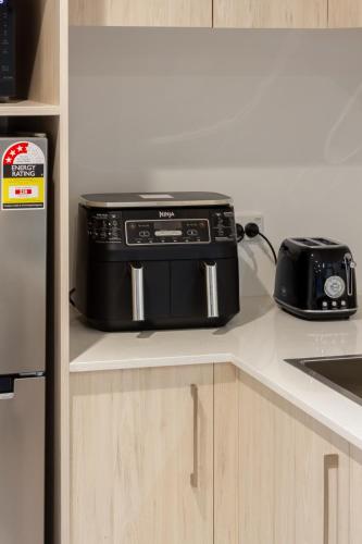 a kitchen counter with a toaster and a toaster oven at Bright & New Studio Unit Walk to Town in Christchurch