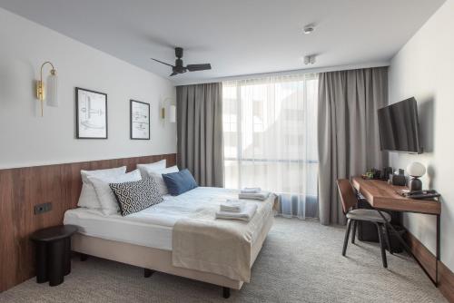 a bedroom with a bed and a desk and a computer at AIRINN Vilnius Airport Hotel RENOVATED 2025 in Vilnius