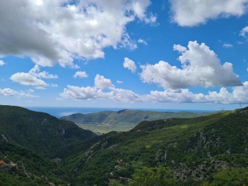 a view of the mountains with the ocean in the background at Черногория Квартира у моря in Rafailovici