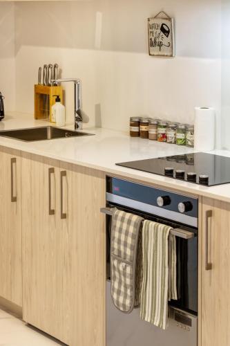 a kitchen with a sink and a stove at Bright & New Studio Unit Walk to Town in Christchurch
