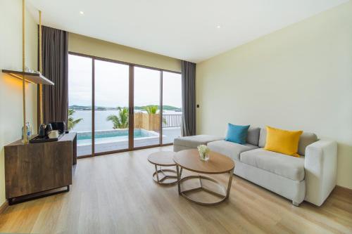 a living room with a couch and a table at Novotel Koh Si Chang in Ban Phanu Rangsi