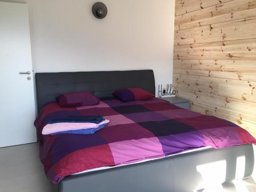 a bedroom with a bed with a purple and pink blanket at Au Chant des Grillons - studio ensoleillé en Gruyère in Estavannens-Dessous