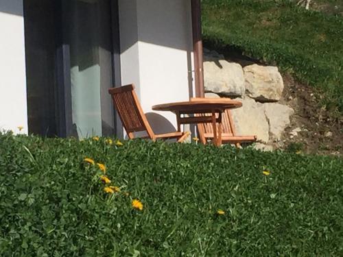 a table and two chairs sitting next to a building at Au Chant des Grillons - studio ensoleillé en Gruyère in Estavannens-Dessous