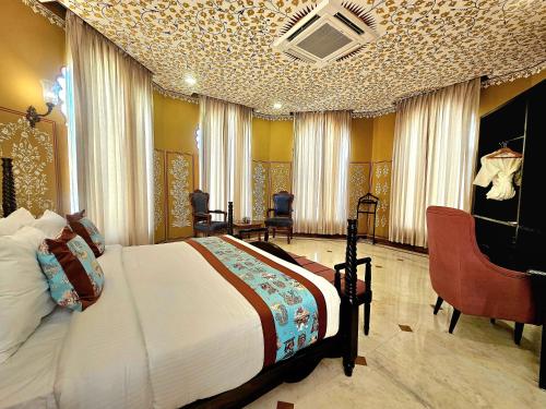 a bedroom with a bed and a desk and chairs at Kesar Bagh Palace Chittorgarh in Chittaurgarh