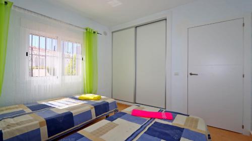 a bedroom with two beds and two windows at R-1935 pool and garden in Torrevieja