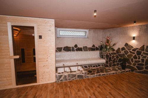a room with a stone wall with a bench in it at Hotel Lesana in Vysoké Tatry