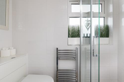 a bathroom with a glass shower and a toilet at Home from Home Garden Free Parking Long Term Stays in Milton Keynes