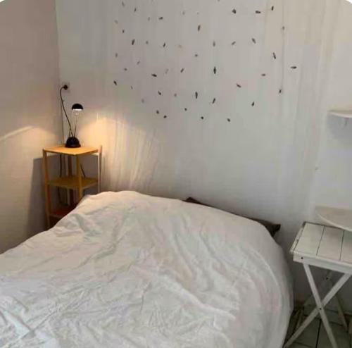 - une chambre dotée d'un lit blanc avec des étoiles noires sur le mur dans l'établissement Residenz La Bergerie, au Cap d'Agde