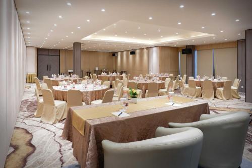 a ballroom with tables and chairs in a room at Orchardz Jayakarta in Jakarta