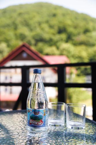 a bottle and two glasses sitting on a table at Апартаменти в центрі Шаян in Shaian