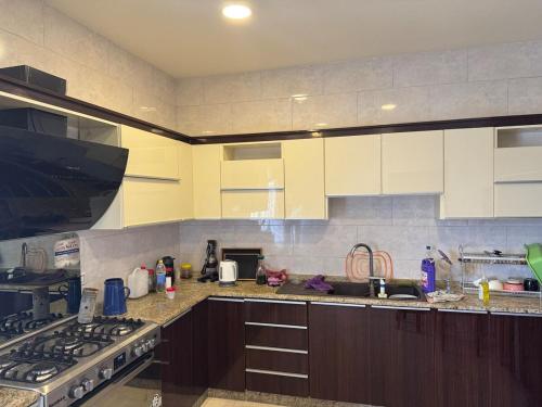 a kitchen with white cabinets and a stove top oven at مزرعة وشالية هوى الوادي 
