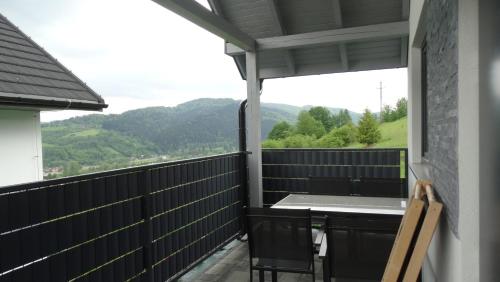 a balcony with a table and a view of the mountains at DOMINO-domek 3 in Krościenko