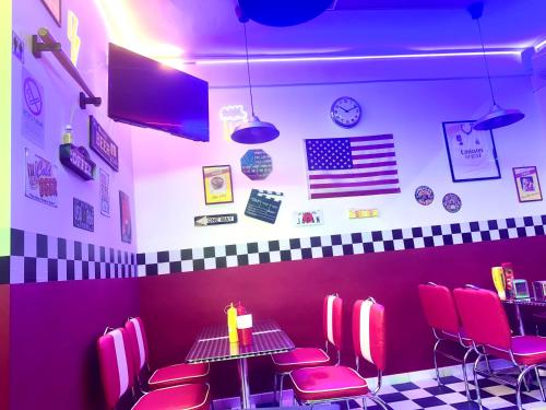 a restaurant with pink chairs and a table and an american flag at Monacos home and food in Naples