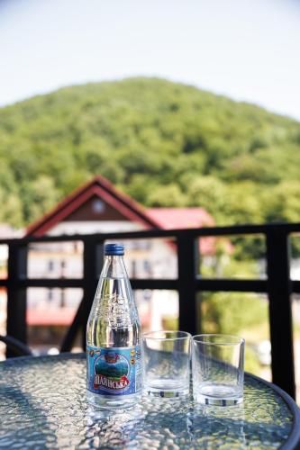 a bottle and two glasses sitting on a table at Апартаменти в центрі Шаян in Shaian