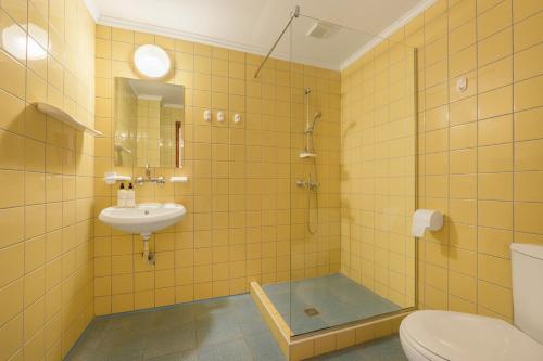 a bathroom with a shower and a sink and a toilet at Morski Briag Hotel in Golden Sands