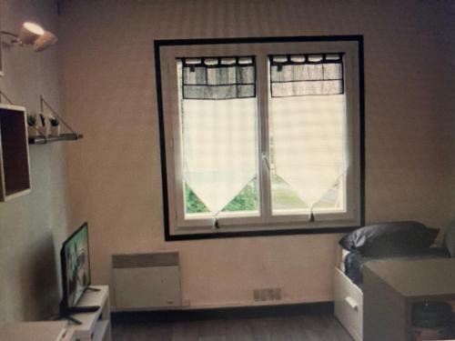 - une chambre dotée d'une fenêtre avec des rideaux et un lit dans l'établissement Studio calme, cosy, lumineux, à Bayonne