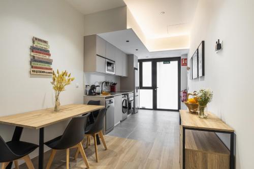 a kitchen and dining room with a wooden table and chairs at Apartamento Río Turia 4 in Valencia