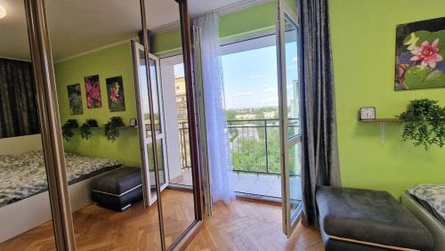 a room with a mirror and a bed and a balcony at Green&Cozy Teofilow District in Łódź