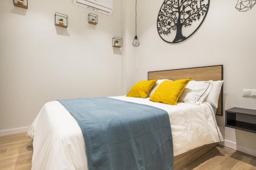 a bedroom with a large bed with yellow pillows at Apartamento Río Turia 4 in Valencia