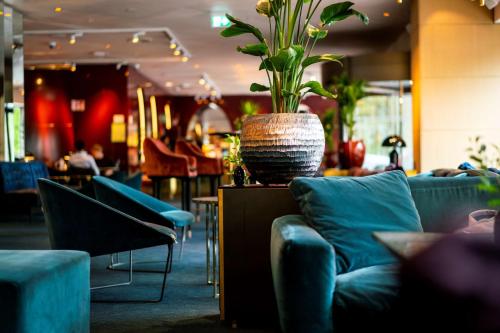 a living room with couches and a vase with a plant at Scandic Anglais in Stockholm