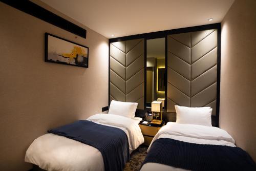 a hotel room with two beds and a mirror at The V Hotel in Baghdad