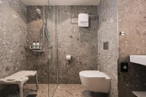 a bathroom with a shower with a toilet and a sink at Scandic Gardermoen in Gardermoen