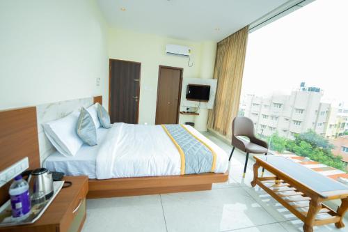 a hotel room with a bed and a desk and a table at Sri Sai Castle IN in Bengaluru