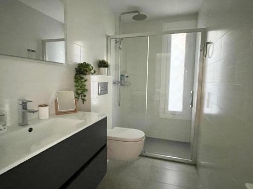 een witte badkamer met toilet en douche bij La Casa de la Brujita with AC License ESS02999 in San Sebastian