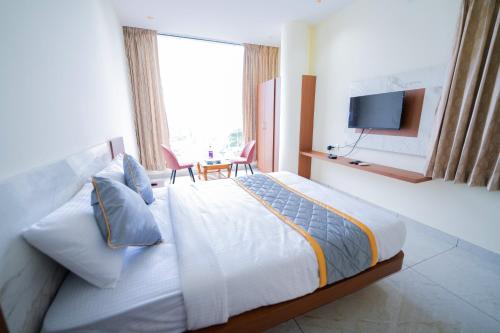 a hotel room with a bed and a television at Sri Sai Castle IN in Bengaluru