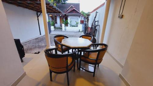 een tafel en stoelen op een balkon met een huis bij Agni Homestay in Timuran