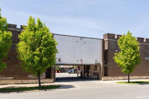 a brick building with two trees in front of it at Admiral Motel By OYO Chicago I-94 in Chicago