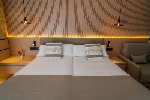 a bedroom with a large white bed and a couch at PortBlue Club Pollentia Resort & Spa in Alcudia